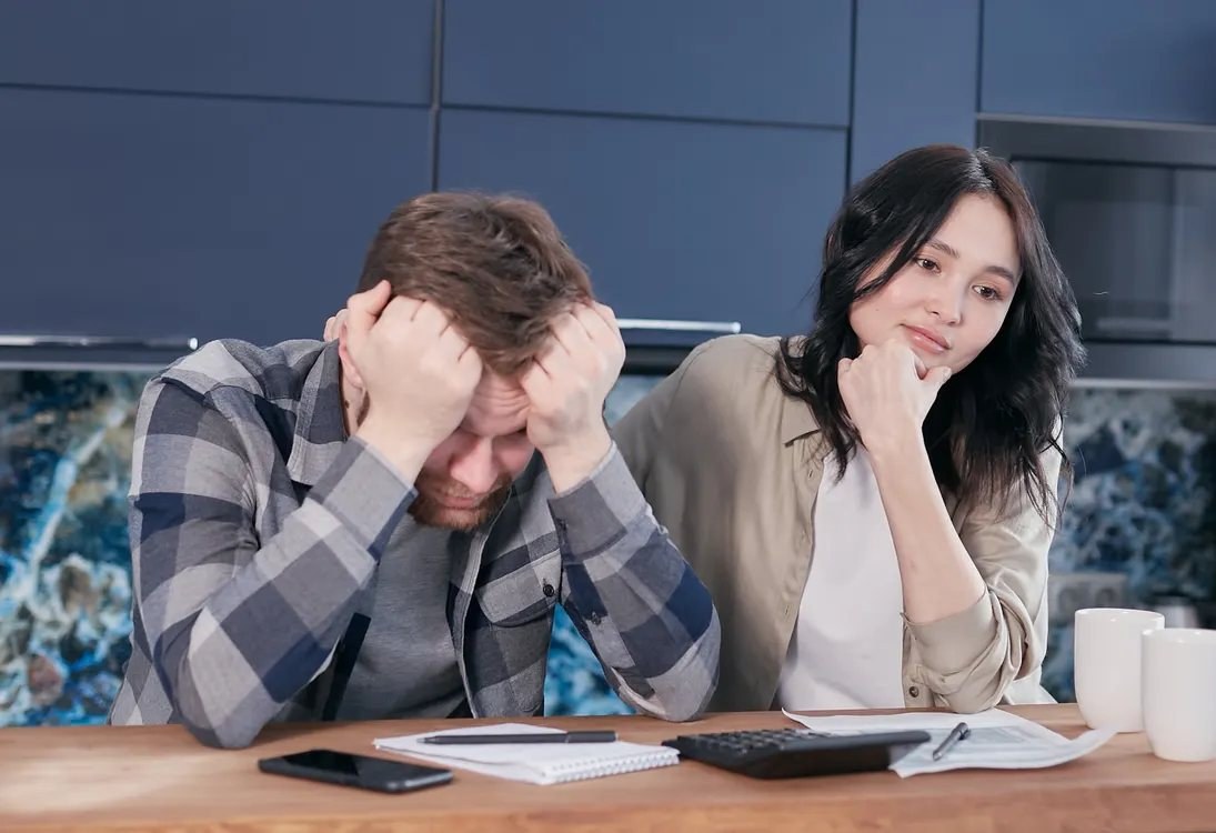 Zwei Menschen prüfen Unterlagen an einem Tisch